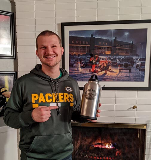 Ben, The Green Bay Guy, holding and pointing to a water bottle with the Green Bay Guy logo on it.