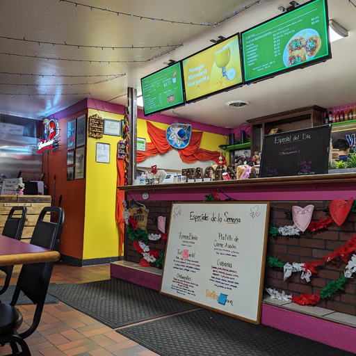 La Carreta's counter with the register and menus displayed in both Spanish and English.